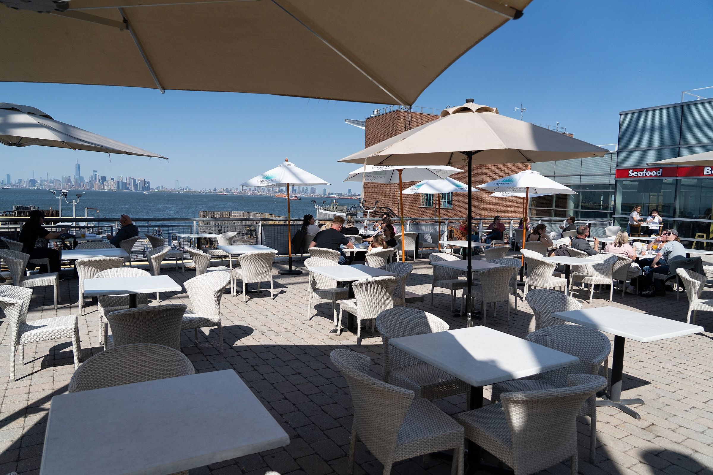 River Dock Cafe's patio at 1 Richmond Terrace, Staten Island — the Manhattan skyline in the distance