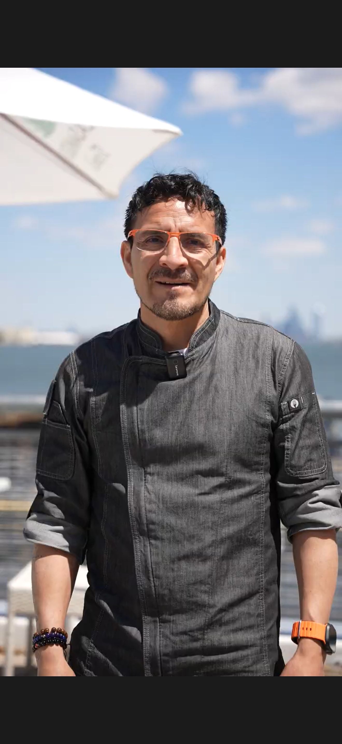 Executive Chef Braulio Bunay of River Dock, photographed on the Staten Island waterfront with the Manhattan skyline beyond